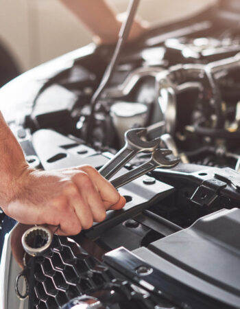 Picture showing muscular car service worker repairing vehicle.